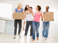 Group of friend roommates moving into new apartment smiling