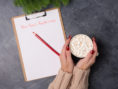 Woman holds a cup of coffee as she plans out her New Year's resolutions.