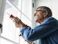 Man using a silicone gun to repair a window