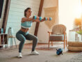 Young woman stays fit by doing an at-home dumbbell workout.
