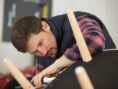 Man touches up the legs on an old chair.