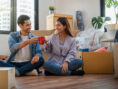 Young couple enjoys some warm drinks in their cozy new fall apartment.