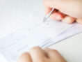 Writing a personal check to pay the rent.